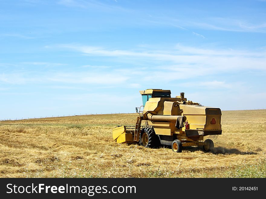 Combine Harvester Working A Wheat Field.