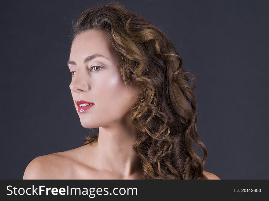 Portrait of a  young beautiful woman on a gray background closeup. Portrait of a  young beautiful woman on a gray background closeup
