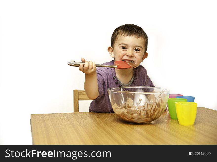 Picture of a happy young toddler mixing ingredients into a bowl isolated on a white background. Picture of a happy young toddler mixing ingredients into a bowl isolated on a white background