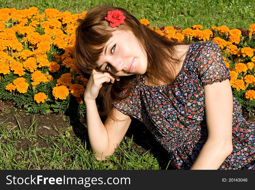 Beautiful girl sitting on meadow with flowers