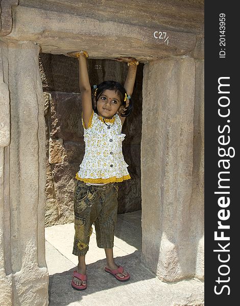 Tiny little girl pretending to lift the upper door slab. Tiny little girl pretending to lift the upper door slab