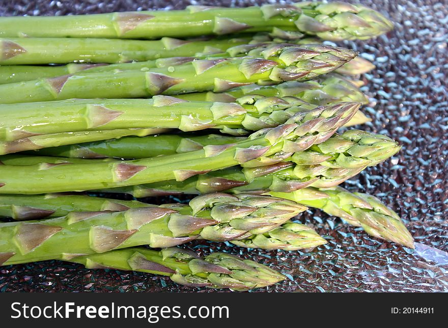 Fresh asparagus tips on glass plate