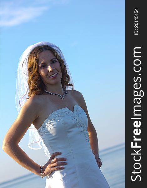 A happy posing at the beach on her wedding day. A happy posing at the beach on her wedding day