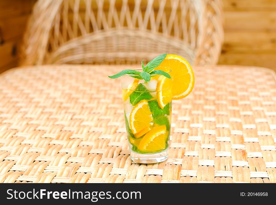 Glass of water with mint leaves and orange on the table. Glass of water with mint leaves and orange on the table