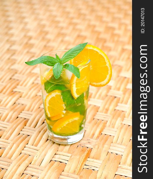 Glass of water with mint leaves and orange on the table. Glass of water with mint leaves and orange on the table