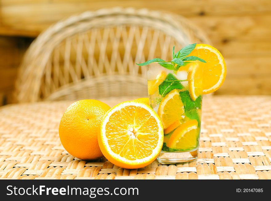 Glass of water with mint leaves and oranges on the table. Glass of water with mint leaves and oranges on the table