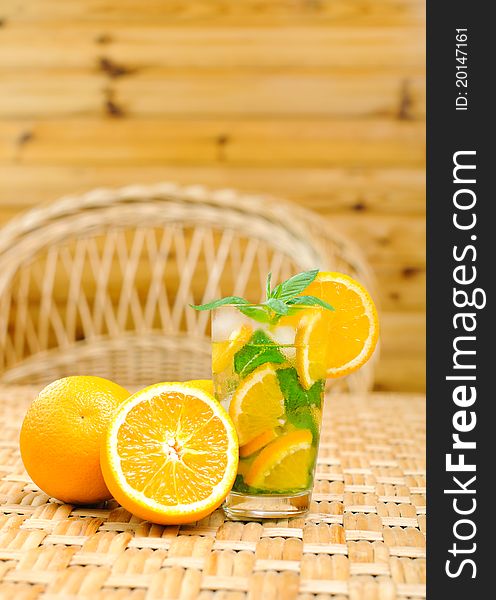 Glass of water with mint leaves and oranges on the table. Glass of water with mint leaves and oranges on the table