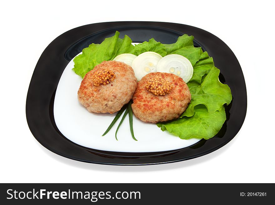 Grilled cutlets on the leaves of lettuce and onion on a plate, isolation on a white background