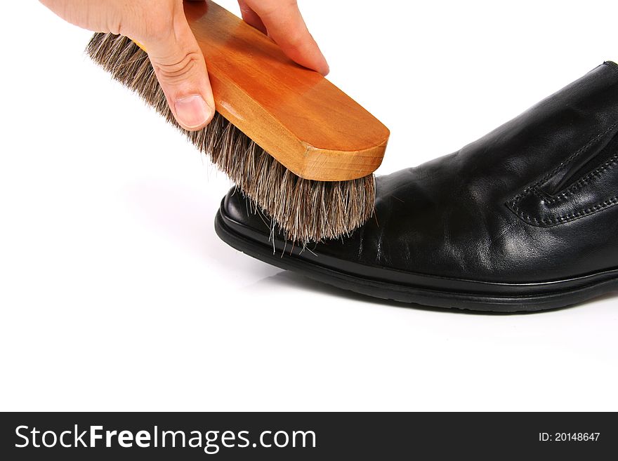 Hand with brush cleaning shoe