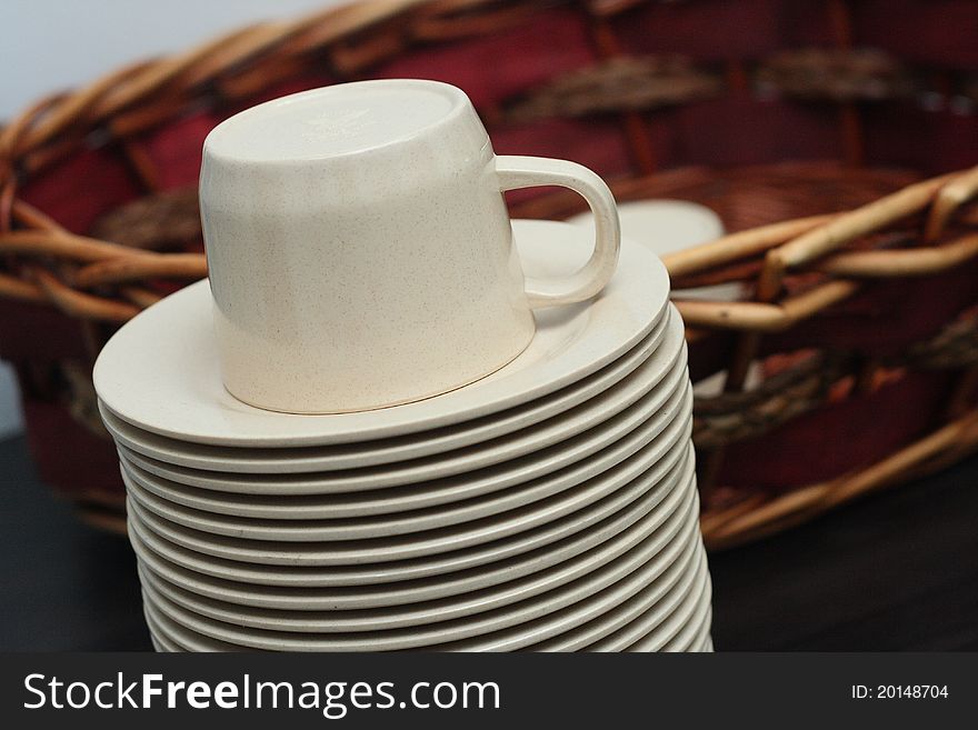 Stacked brown empty teacups with cane basket at a function. Stacked brown empty teacups with cane basket at a function