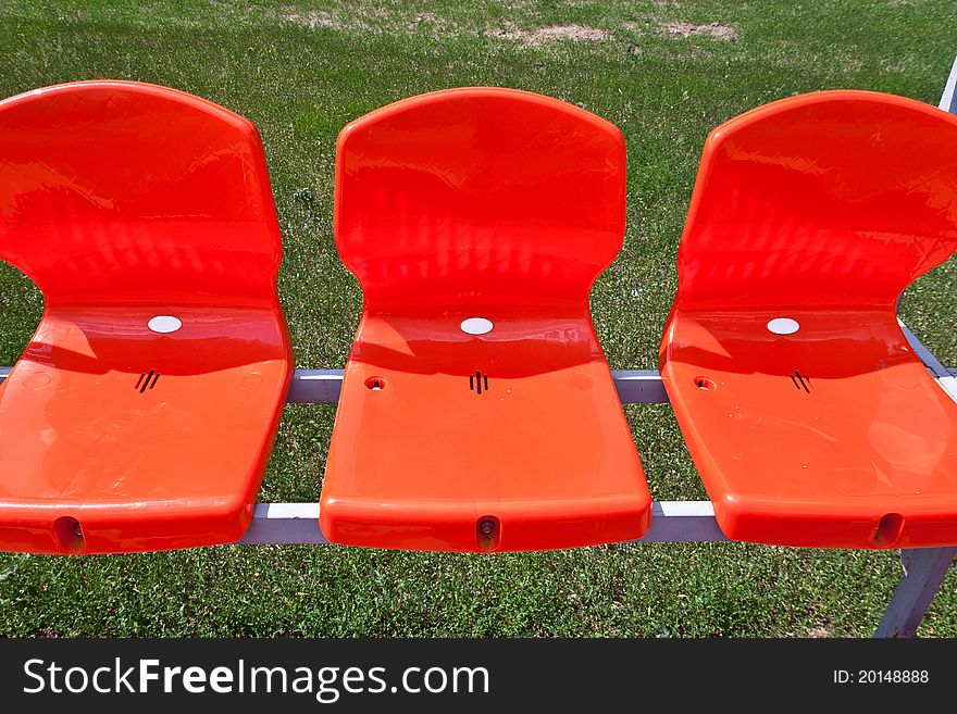 Three red plastic seats at stadium. Three red plastic seats at stadium