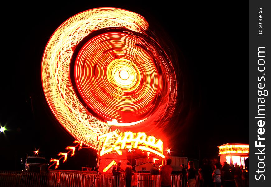 A picture of a fair ride at night. A picture of a fair ride at night.