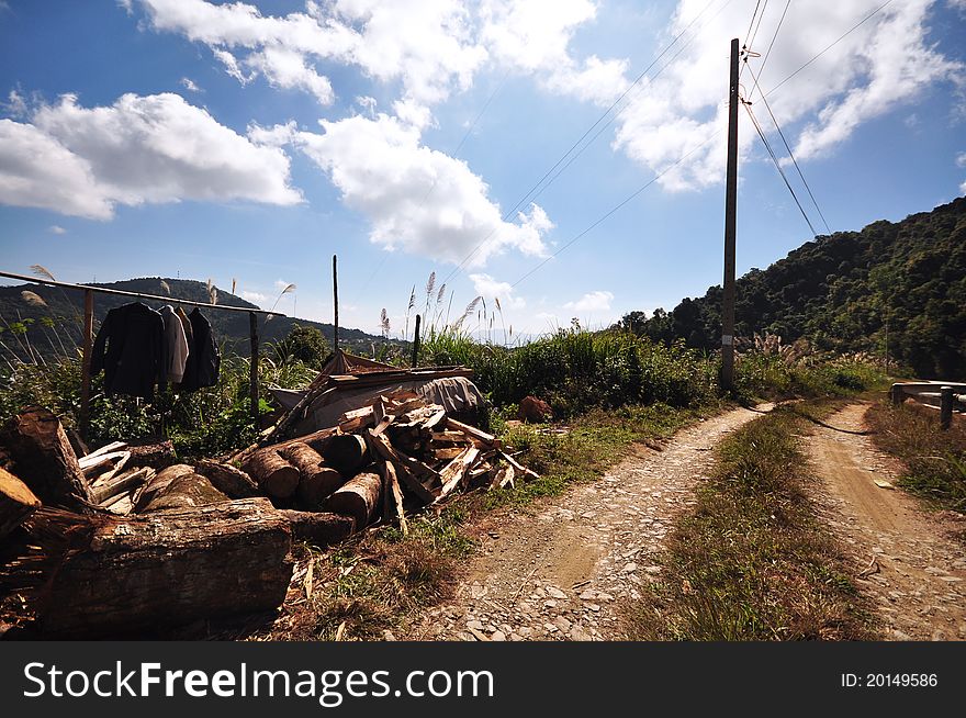 Local dirt road with wood logs on mountain. Local dirt road with wood logs on mountain