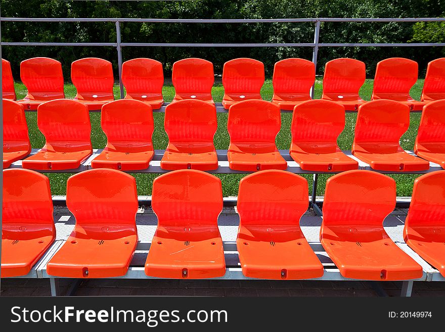 Three rows of red plastic seats. Three rows of red plastic seats