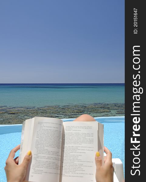 Girl reading a book over the sea