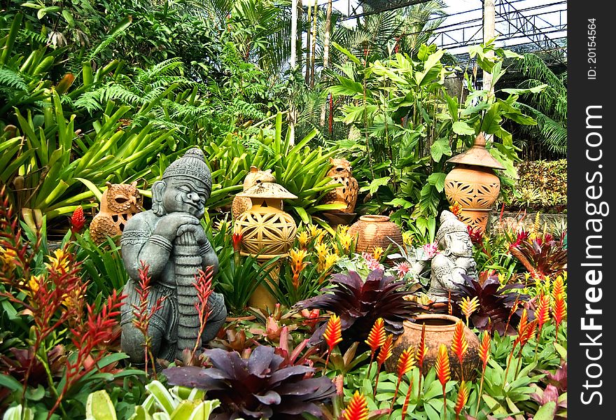 Various terracotta pottery between green plants