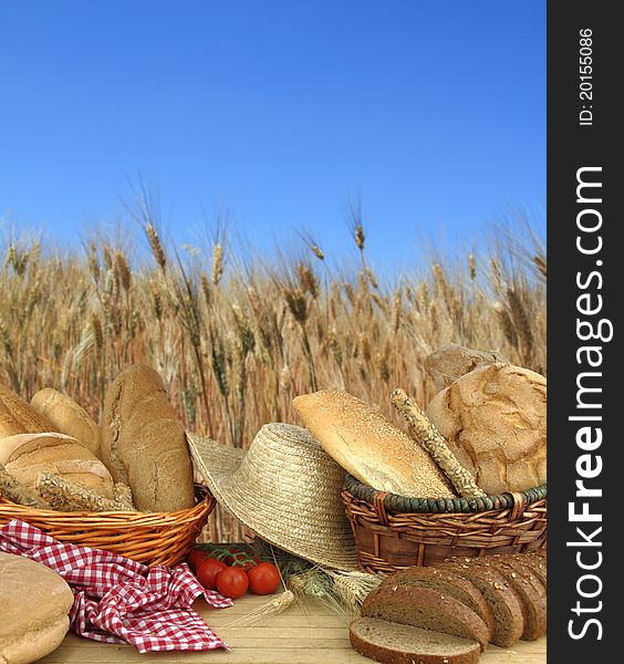 Various types of bread in front of a wheat field. Various types of bread in front of a wheat field