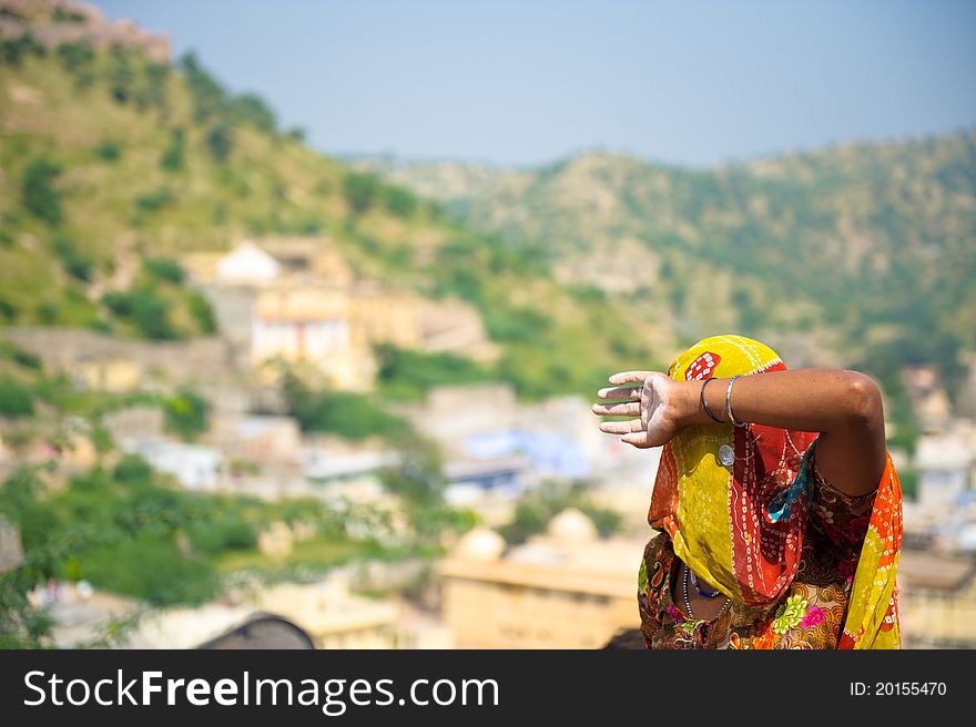 Unidentified Indian woman with a sari covering her face blocking the sunny sun