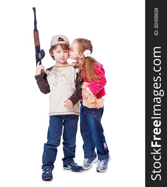 A girl is kissing a boy with the gun. Isolated on a white background