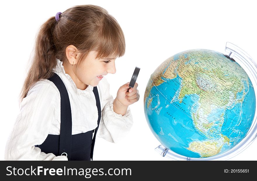 A girl is looking through the loupe at the globe. A girl is looking through the loupe at the globe