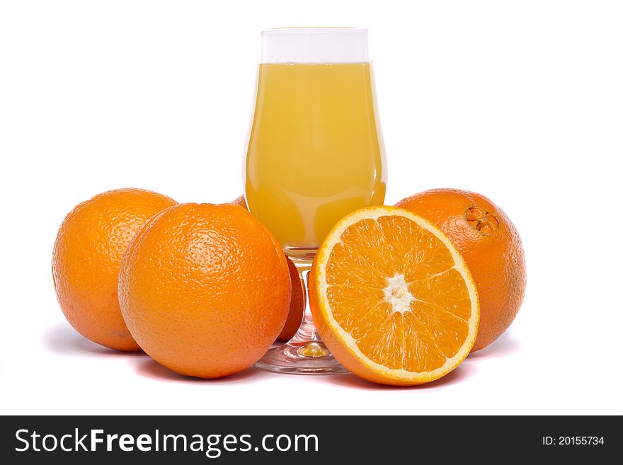 Close view of a bunch of oranges with glass of juice isolated on a white background. Close view of a bunch of oranges with glass of juice isolated on a white background