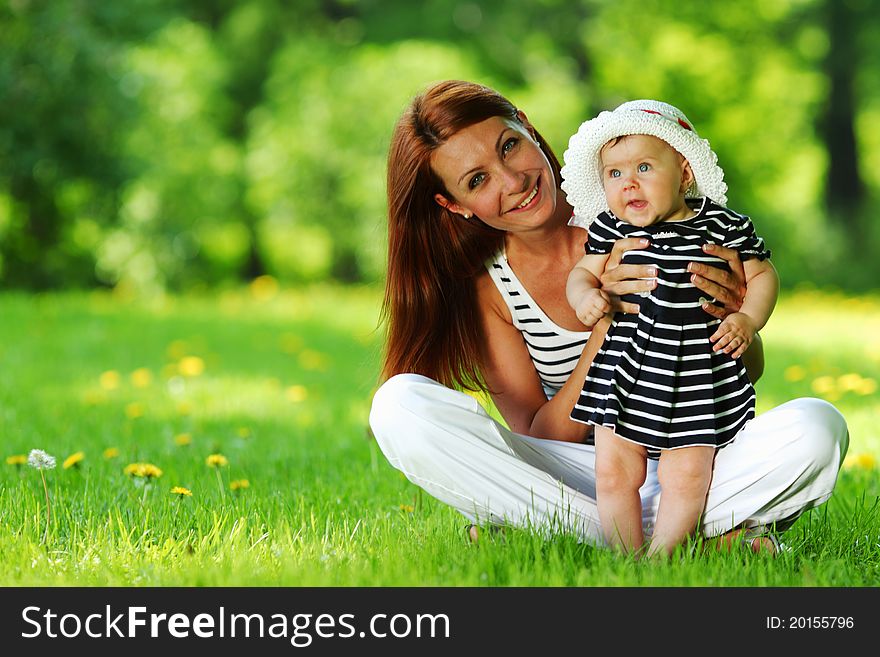 Mother And Daughter On The Green Grass