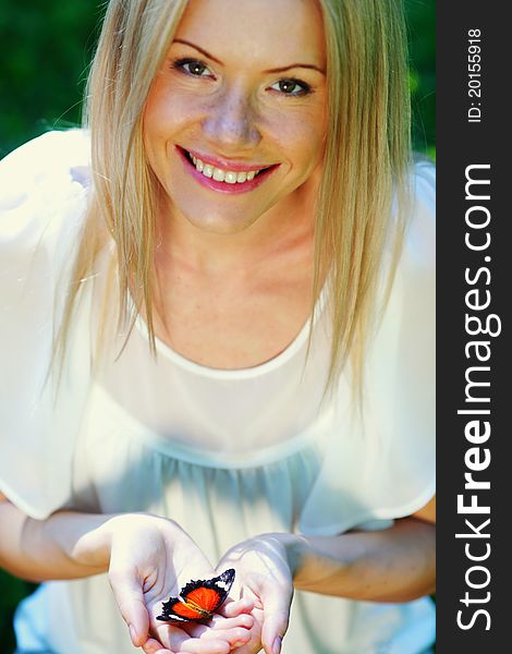 Woman playing with a butterfly on green grass