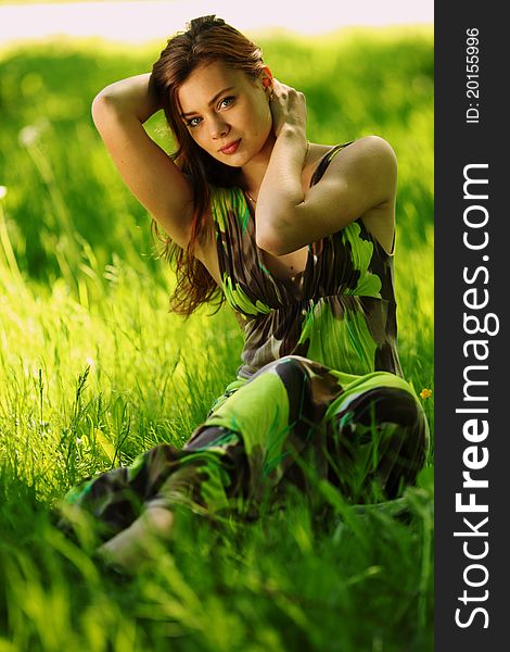 Brunette Sitting On Green Grass