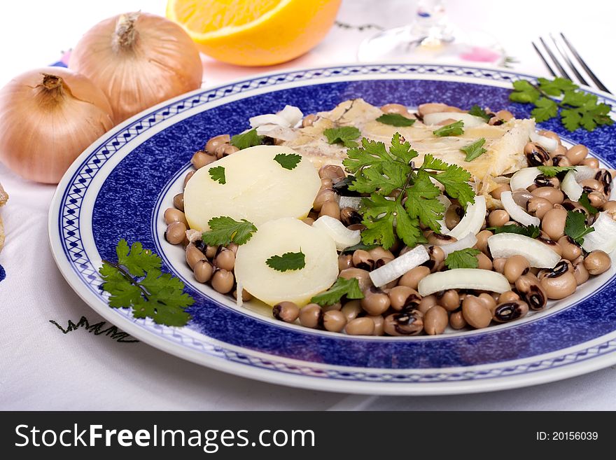 View of a meal with brown beans with cod and potatoes, tempered with olive oil and parsley. View of a meal with brown beans with cod and potatoes, tempered with olive oil and parsley.