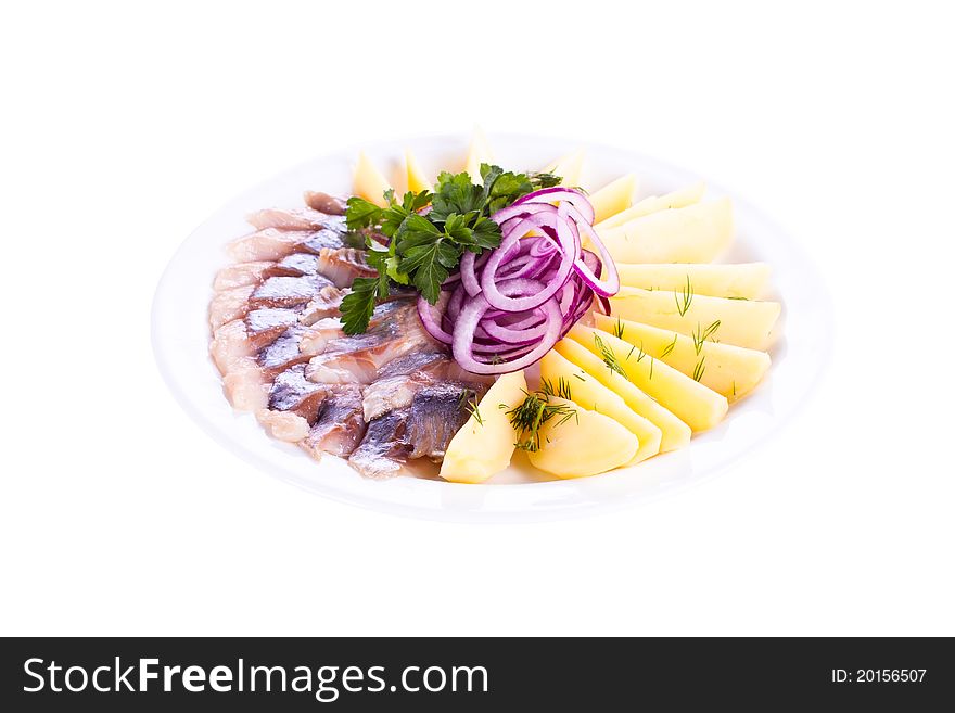 Sliced вЂ‹вЂ‹herring with potatoes and onions to a plate. Sliced вЂ‹вЂ‹herring with potatoes and onions to a plate.