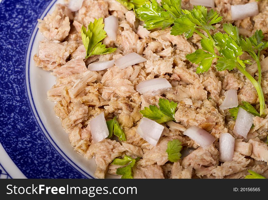View of a meal of tuna with onion and parsley.