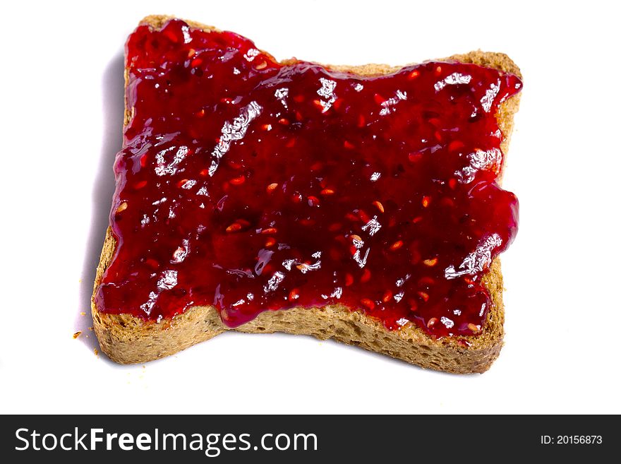 Close view of a toasted bread with berry jam spread isolated on a white background. Close view of a toasted bread with berry jam spread isolated on a white background.