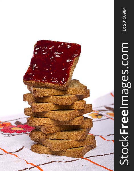 Close view of a toasted bread with berry jam isolated on a white background. Close view of a toasted bread with berry jam isolated on a white background.