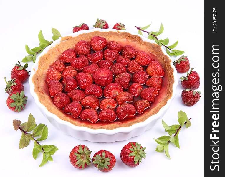 Strawberry Tart decorated with strawberries and mint twigs on a white background