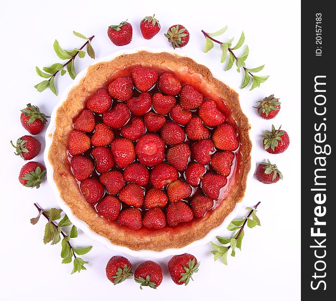 Strawberry Tart decorated with strawberries and mint twigs on a white background