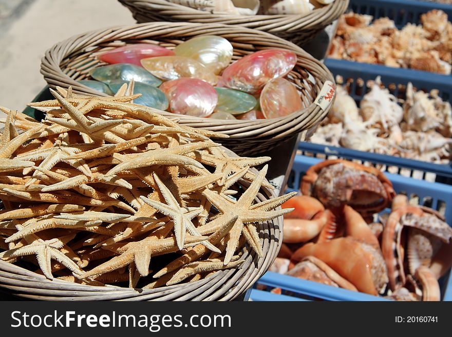 Large baskets of sea shells and star fish for sale at a sea side market. Large baskets of sea shells and star fish for sale at a sea side market.