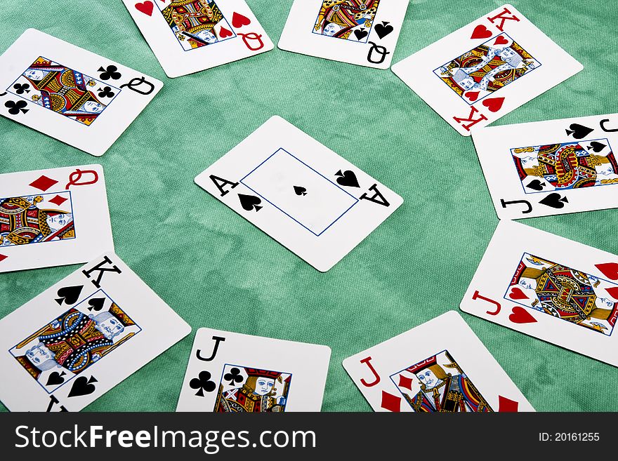 Close up view of a circle of playing cards spread on a green cloth table. Close up view of a circle of playing cards spread on a green cloth table.