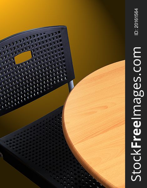 Image of a wooden table and a black plastic chair with nobody sitting on (empty). Emptiness. Image of a wooden table and a black plastic chair with nobody sitting on (empty). Emptiness.