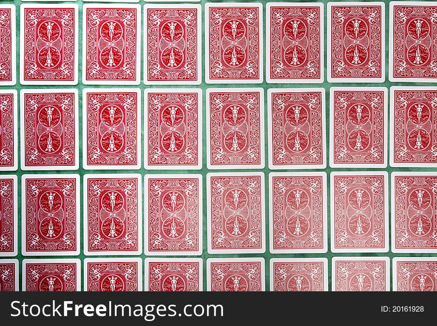 Close up view of a bunch of flipped playing cards spread on a green cloth table. Close up view of a bunch of flipped playing cards spread on a green cloth table.