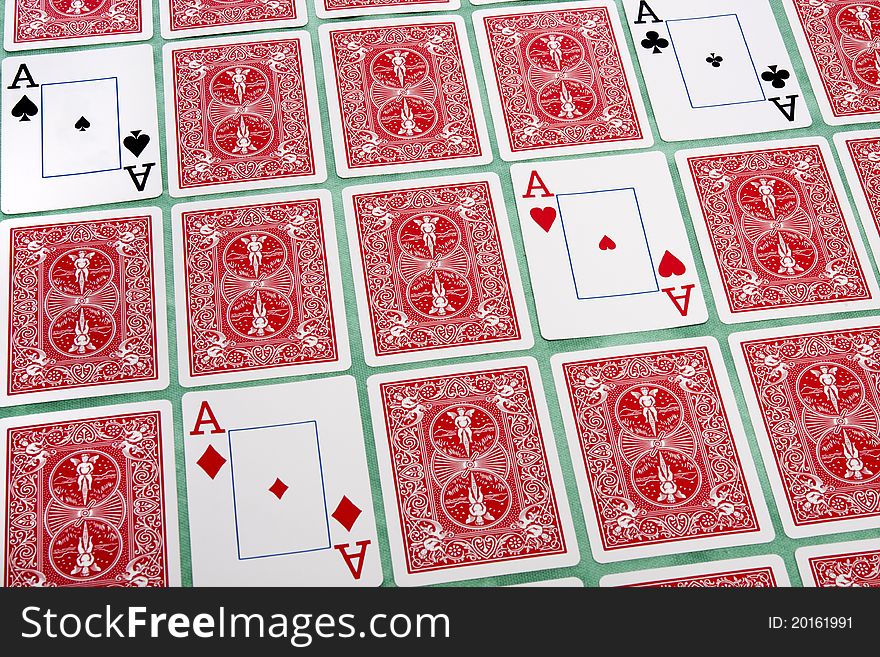 Close up view of a bunch of flipped playing cards spread on a green cloth table. Close up view of a bunch of flipped playing cards spread on a green cloth table.