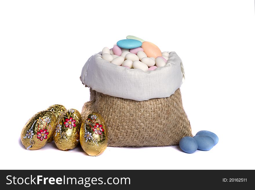 Close up view of sweet almonds and chocolate eggs inside a sack isolated on a white background. Close up view of sweet almonds and chocolate eggs inside a sack isolated on a white background.