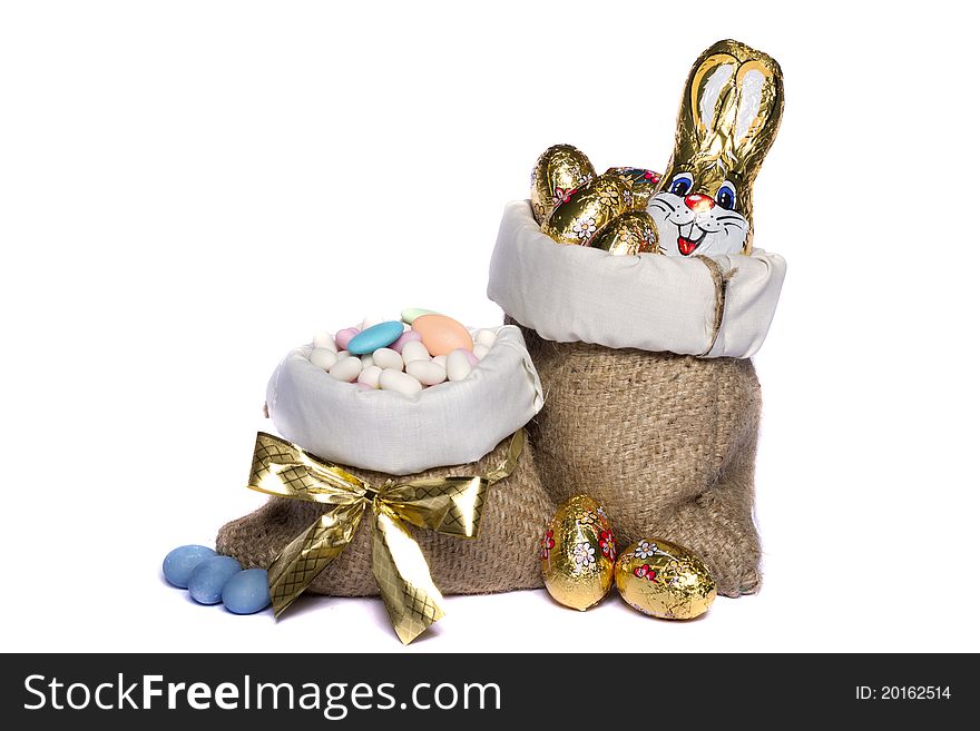 Close up view of sweet almonds and chocolate eggs inside a sack isolated on a white background. Close up view of sweet almonds and chocolate eggs inside a sack isolated on a white background.