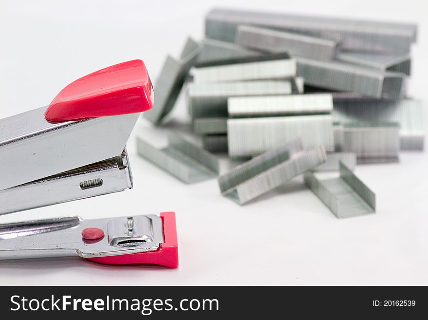 Stapler and staples on white background