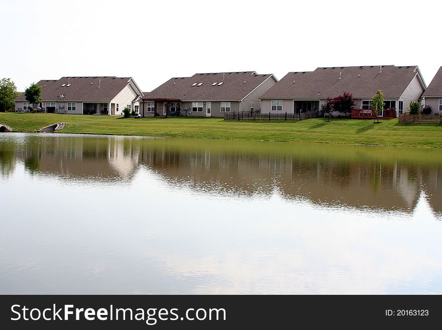 Several suburban duplex houses reflecting onto a lake. Several suburban duplex houses reflecting onto a lake