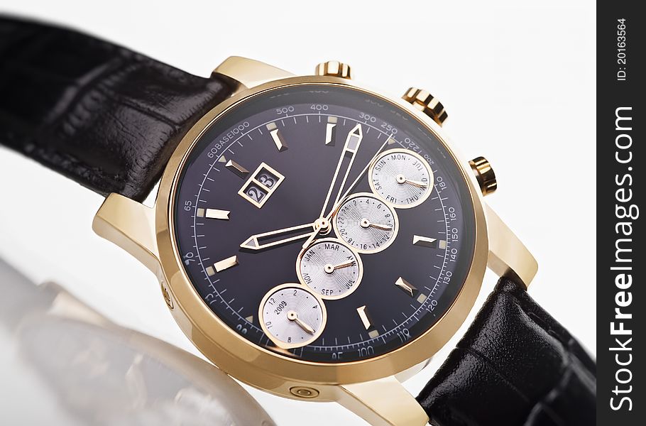 Gold men's wristwatch with black leather strap on a white background