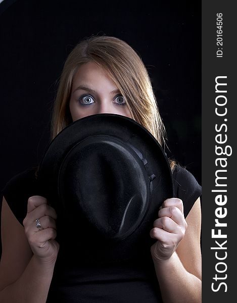 A blond girl looking over the hat