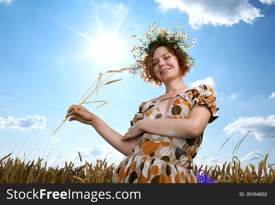 Woman in wheat field under blue sky