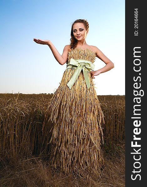 Woman in wheat field under blue sky