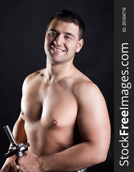 Athlete is holding a dumbbells and smiling. Athlete is holding a dumbbells and smiling