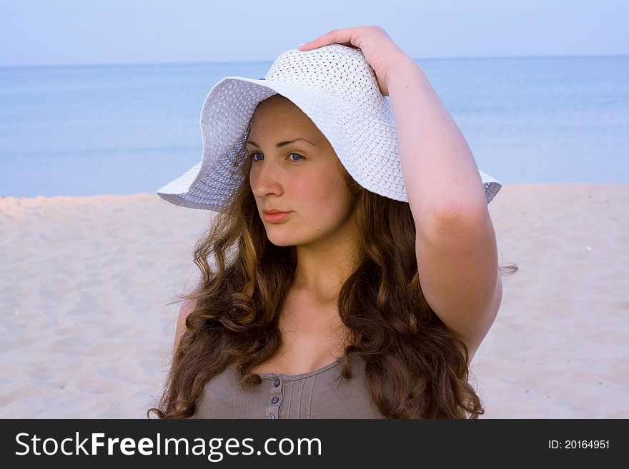 Portrait of woman wearing a hat from the sun on a blue background of the sea. Portrait of woman wearing a hat from the sun on a blue background of the sea